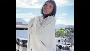 Linda amadora mostrando seios naturais na varanda ao ar livre